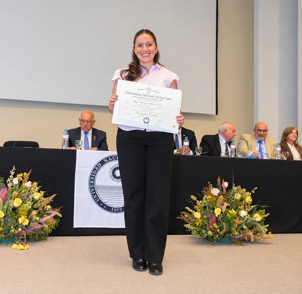 Graduación universitaria con diploma y flores